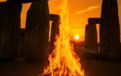 Hoguera encendida frente al monumento megalítico de Stonehenge, símbolo del solsticio de verano y del despertar de la Luz interior.